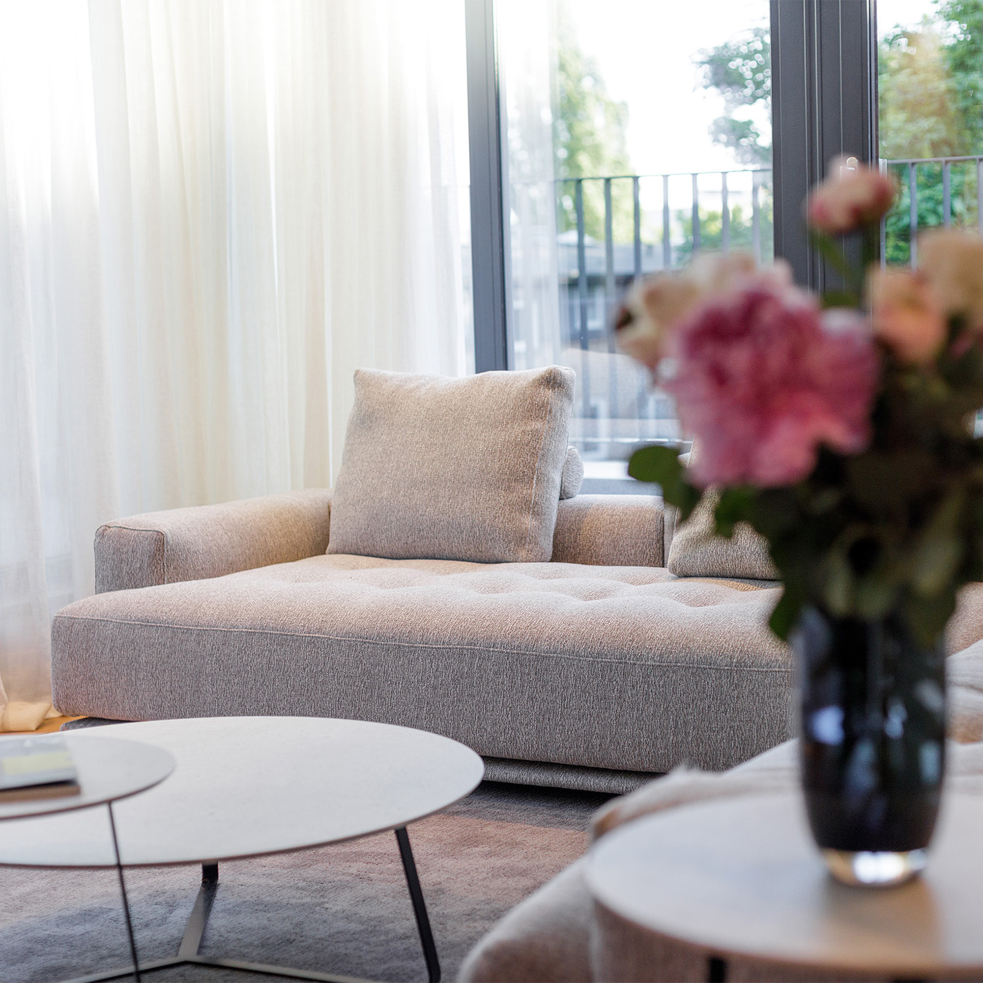 modernes Wohnzimmer beiges Stoffsofa bodentiefe Fenster